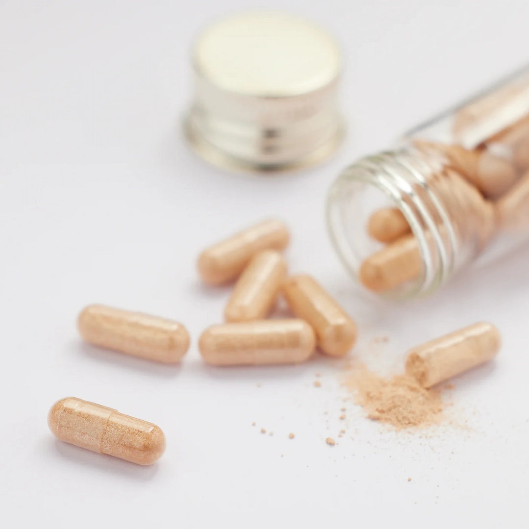 Aesthetic view of Pycnogenol tablets spilling from bottle with cap beside